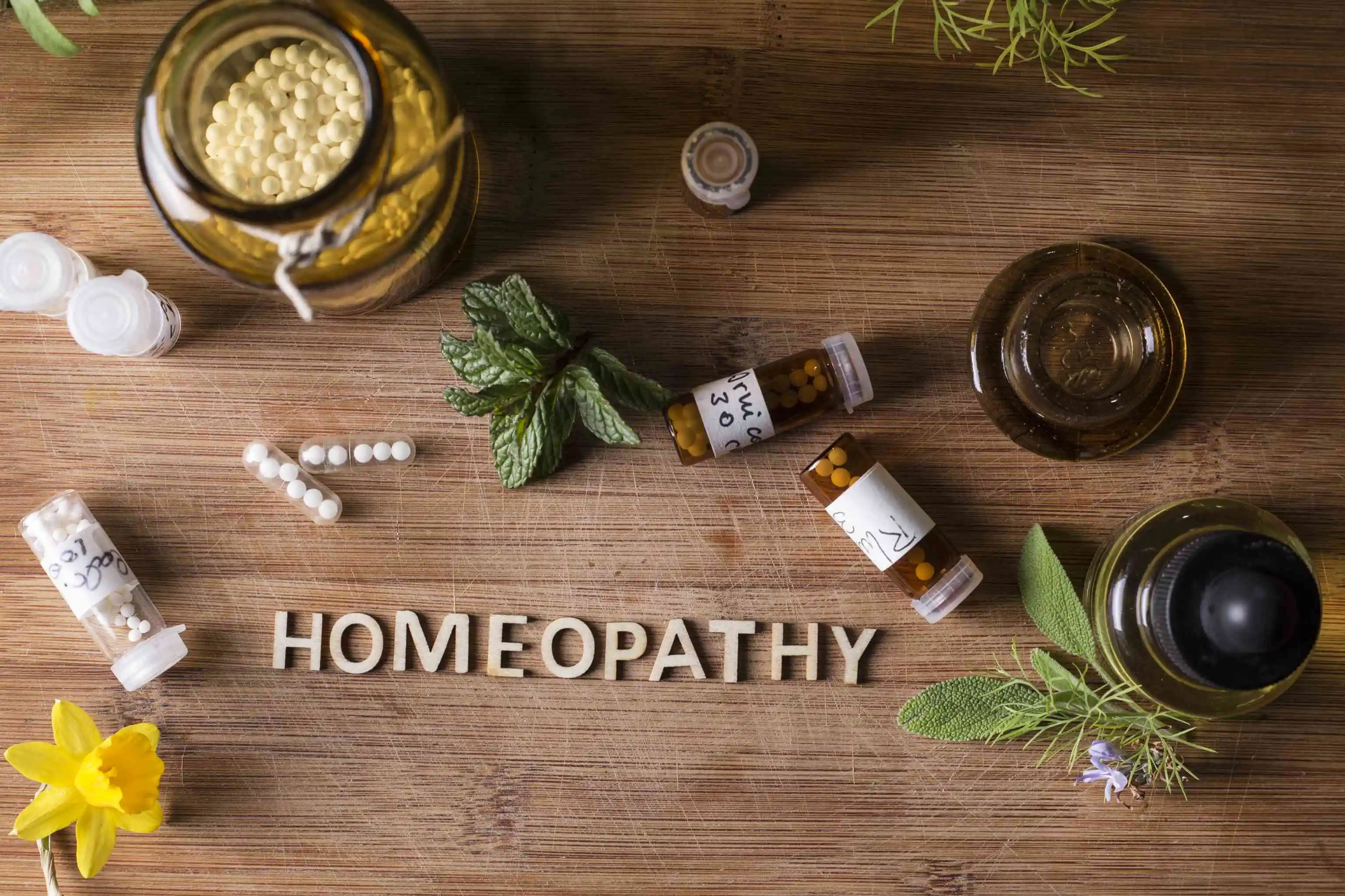 Table with written text Homeopathy, homeopathy globules and bottles